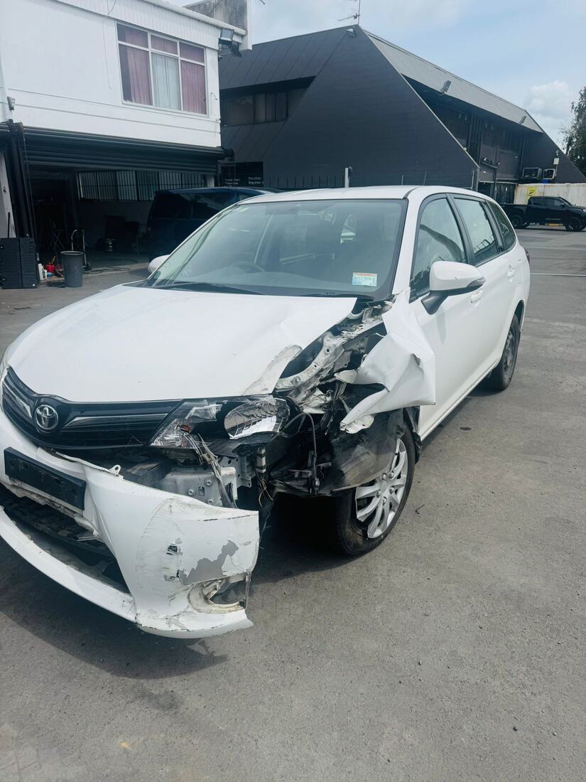 White Toyota wagon with heavy front-end crash damage before pickup