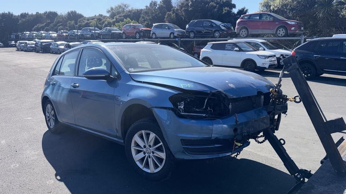 Damaged blue Volkswagen Golf being winched onto a tow truck