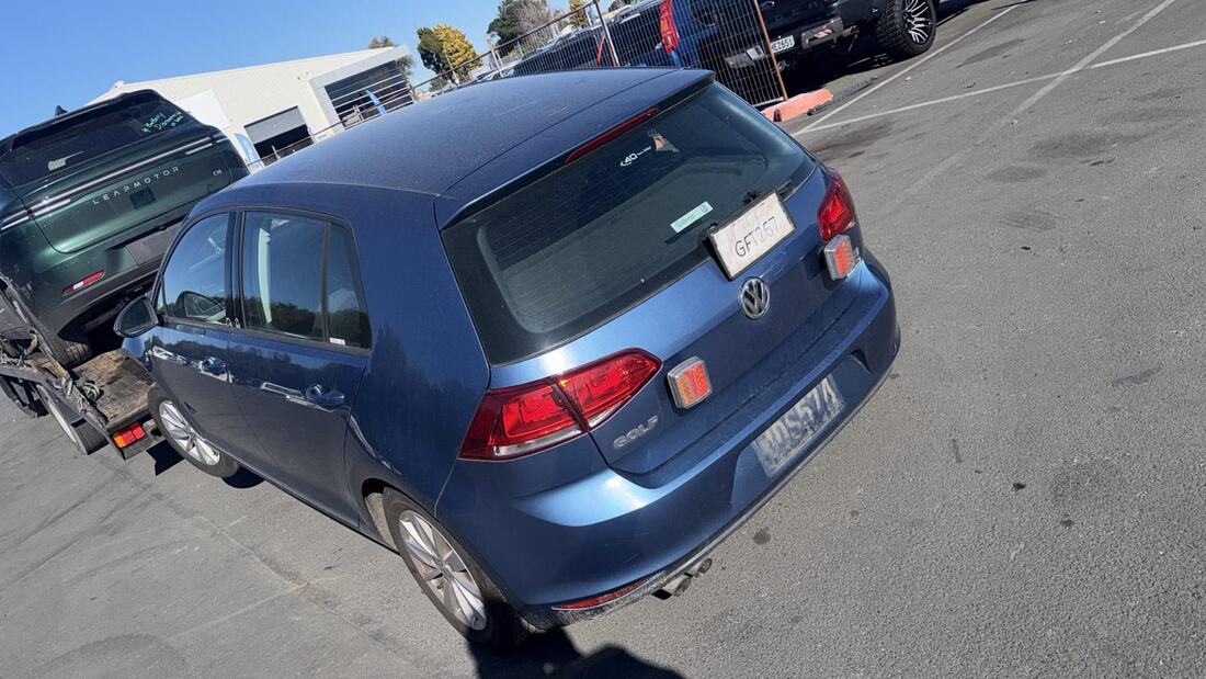 Blue Volkswagen Golf loaded onto a Cash For Cars Whakatāne tow truck